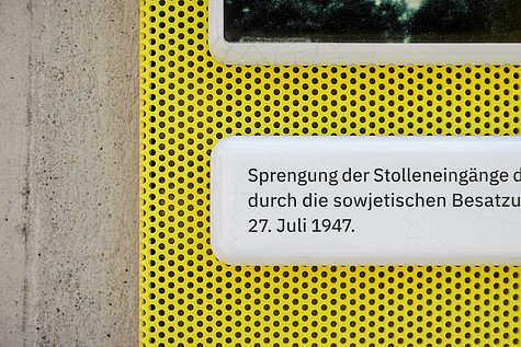 Ausschnitt einer Informationstafel mit der Aufschrift: ‚Sprengung der Stolleneingänge durch die sowjetischen Besatzungstruppen am 27. Juli 1947.‘