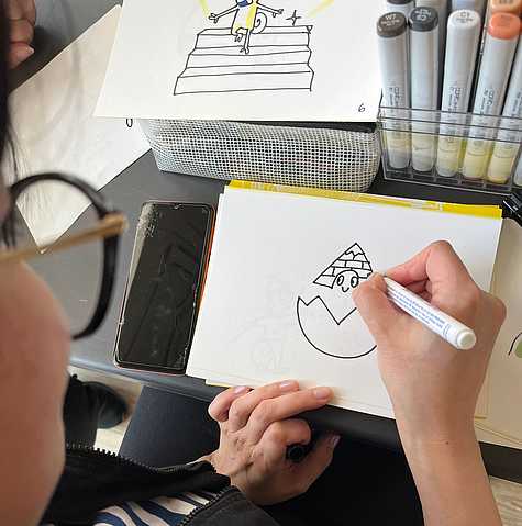 Hand zeichnet ein einfaches Symbol mit schwarzem Marker als Teil der gemeinsamen Ideenentwicklung für das Corporate Design.