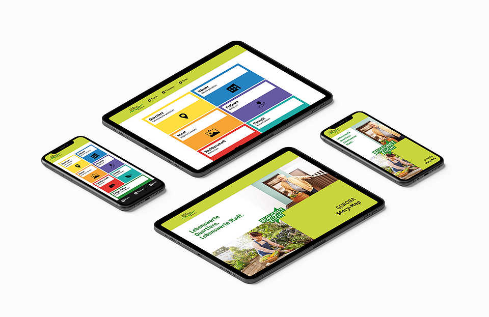 Vier mobile Geräte (zwei Smartphones und zwei Tablets) liegen auf einer weißen Fläche. Alle Geräte zeigen die GEWOBA Story-Map Webseite mit bunten, quadratischen Menüs für verschiedene Themen wie 'Einblicke', 'Orte', 'Themen', und 'Hintergründe'. Die Webseite ist farbenfroh gestaltet, mit gelben, grünen, blauen und roten Bereichen. Ein Smartphone und ein Tablet zeigen eine spezifische Seite mit dem Titel 'Lebenswerte Quartiere für eine lebenswerte Stadt'.