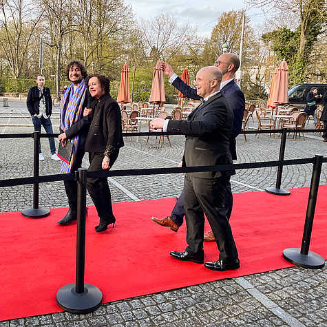Preisträgerin Maria Schrader schreitet über den roten Teppich des Filmfests Bremen, flankiert von Zuschauer:innen hinter Absperrungen auf dem gepflasterten Platz.
