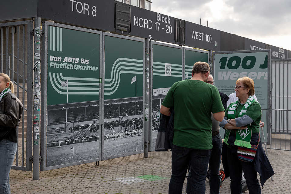 Gestaltete Eingangstore am Weserstadion mit historischem Stadionfoto und QR-Code