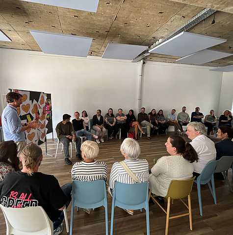 Alle Workshopteilnehmenden sitzen im Kreis und tauschen ihre Ideen und Ergebnisse gemeinsam aus.