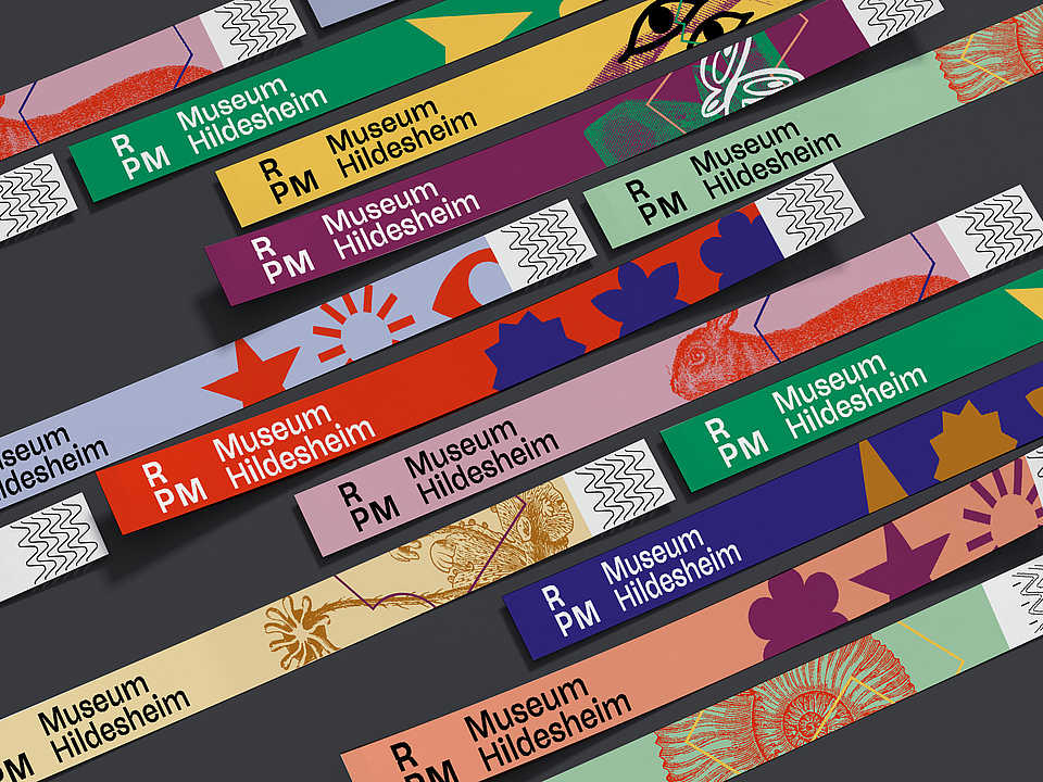 Grafische Gestaltung mit farbigen, diagonal angeordneten Formen und Symbolen im Corporate Design des RPM Museums